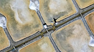 French salt maker Francois Durand harvests sea salt from a salt pan in Le Pouliguen, west France, August 5, 2022