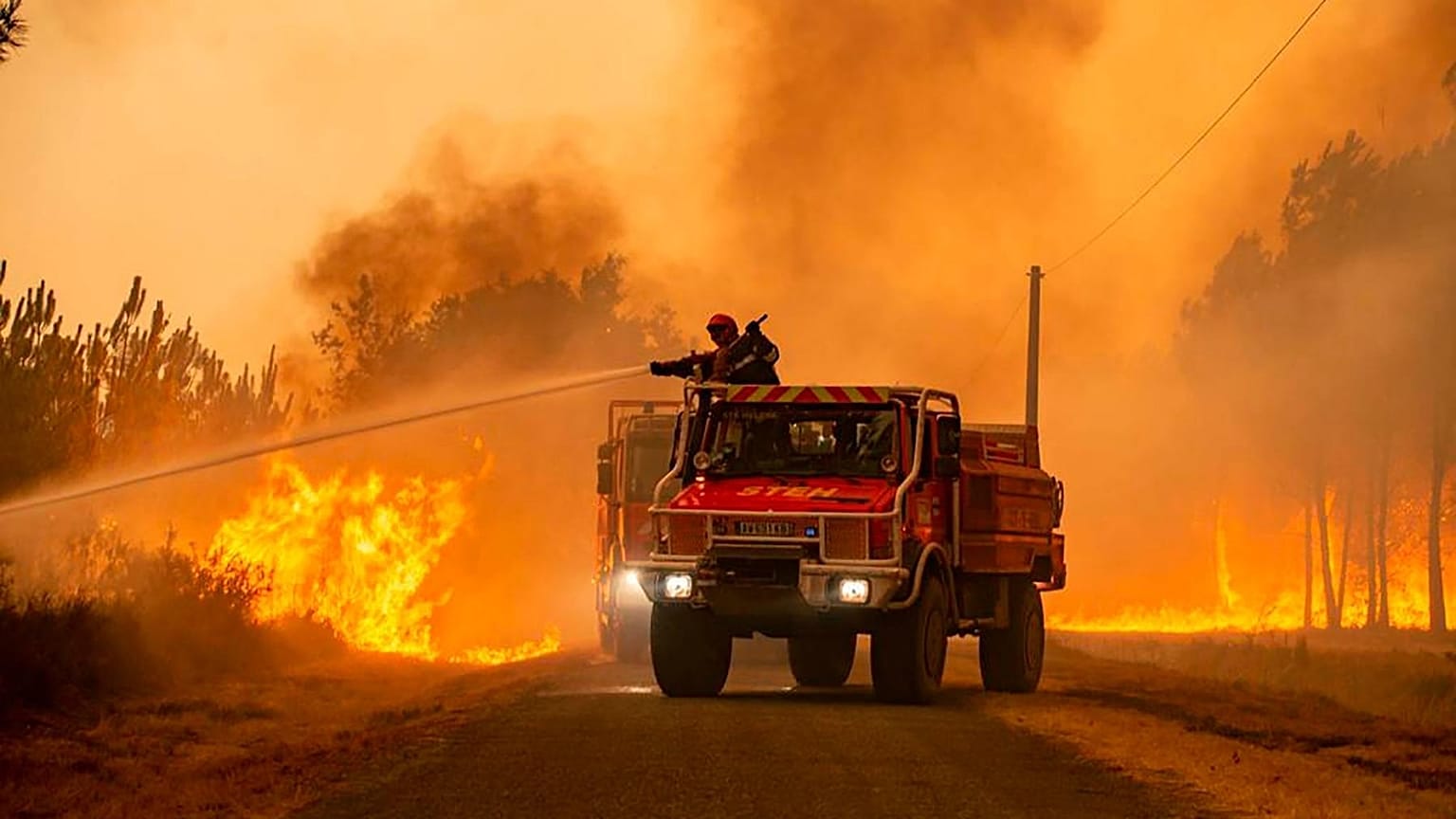 Firefighters tackling a blaze near Hostens, south of Bordeaux, southwestern France, Wednesday, Aug. 10, 2022.