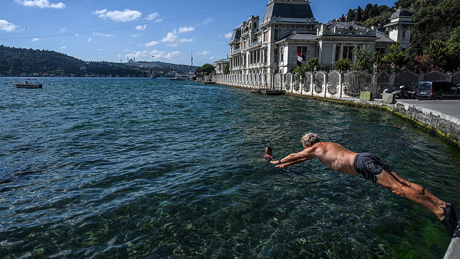 A swimmer dives into the water in the Bosphorus strait in Istanbul's Bebek district