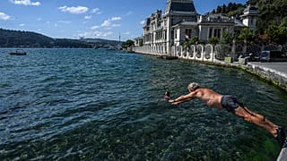 A swimmer dives into the water in the Bosphorus strait in Istanbul's Bebek district
