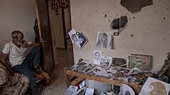داخل غرفتها ـ مرسمها، يجلس عدنان والد الرسّامة الفلسطينية الشابة دنيانا العمور التي قتلت في منزلها بخانيونس بقذيفة إسرائيلية، 5أغسطس 2022.