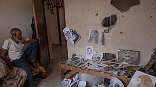 داخل غرفتها ـ مرسمها، يجلس عدنان والد الرسّامة الفلسطينية الشابة دنيانا العمور التي قتلت في منزلها بخانيونس بقذيفة إسرائيلية، 5أغسطس 2022.