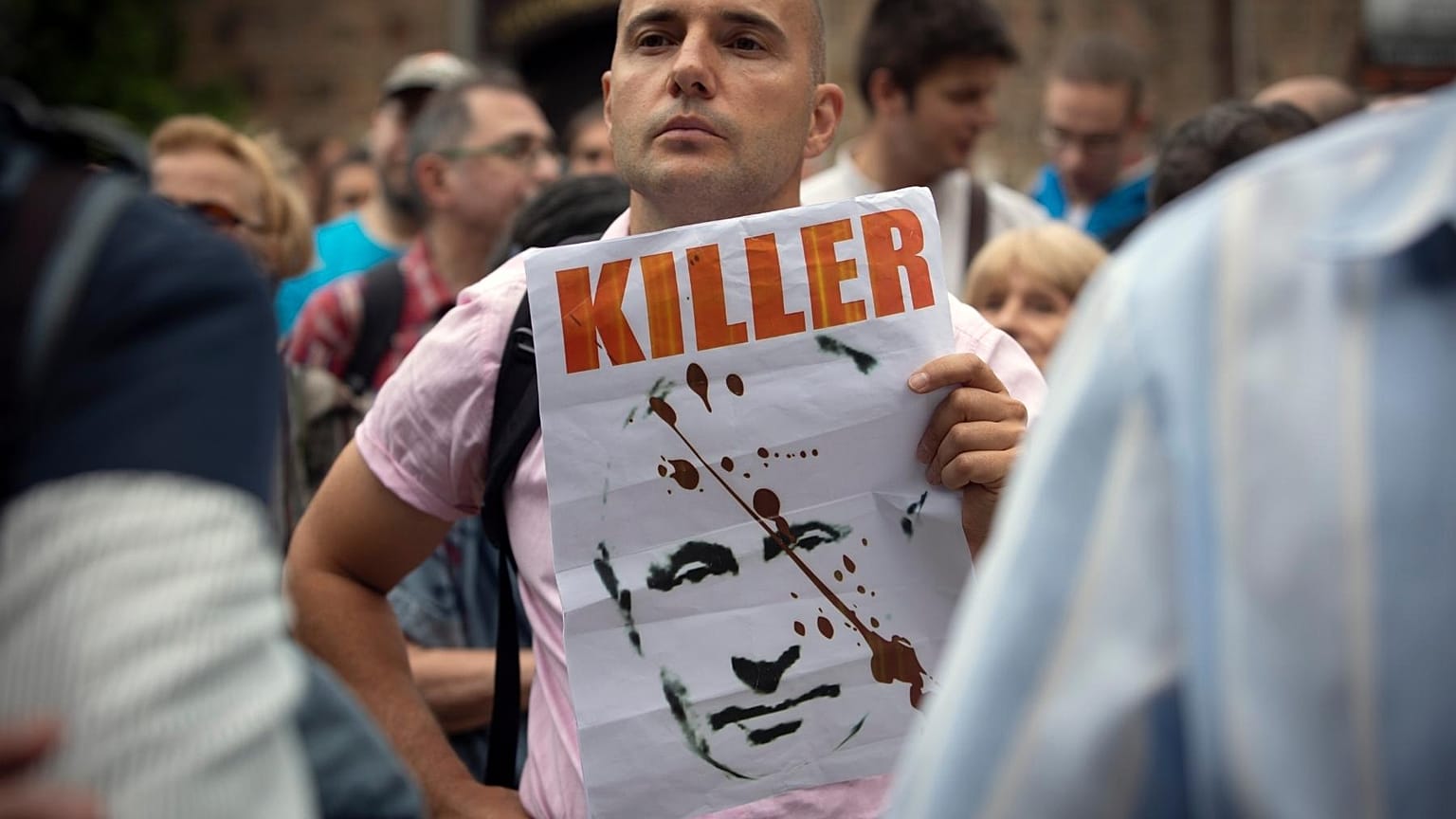 A protester holds a poster depicting Russia's President Putin along with sign "Killer" during a protest rally in downtown Sofia, 10 August 2022