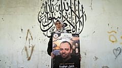 الفلسطينية دلال عواودة تحمل صورة لزوجها المعتقل في السجون الإسرائيلية والمضرب عن الطعام احتجاجاً على اعتقاله إدارياً، 11 أغسطس 2022.