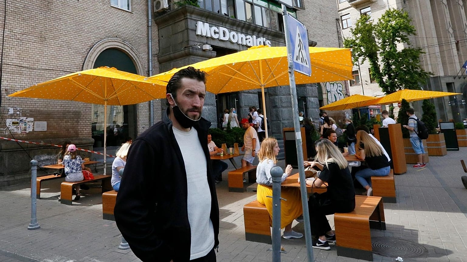 FILE - People, some of them still in masks to protect against coronavirus, enjoy outdoor McDonald's meal in downtown Kyiv, Ukraine, on June 9, 2020.