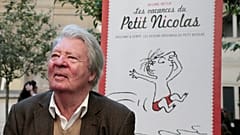Sempé posiert vor dem Plakat einer Ausstellung, die seinem "kleinen Nick" gewidmet ist (2014)