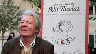 Sempé posiert vor dem Plakat einer Ausstellung, die seinem "kleinen Nick" gewidmet ist (2014)