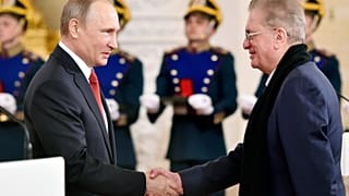 Mikhail Piotrovsky, direttore del Museo dell'Ermitage di San Pietroburgo, stringe la mano a Vladimir Putin