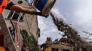 Um trabalhador limpa destroços dos bombardeamentos na região de Donetsk, no leste da Ucrânia
