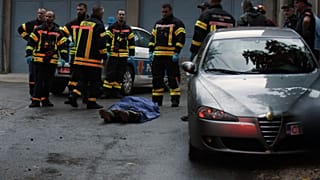 رجال إطفاء يقفون بجانب جثة في موقع الهجوم في سيتيني، على بعد حوالي 30 كم غرب بودغوريتشا، الجبل الأسود، الجمعة، 12 أغسطس، 2022