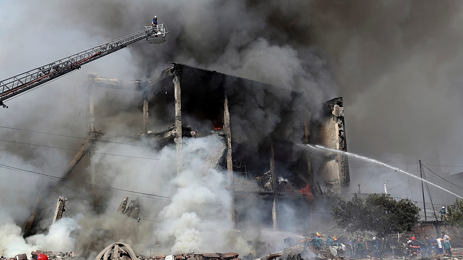 Firefighters extinguish flames as smoke rises from Surmalu market