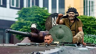 Ukrainian servicemen ride in a tank on a street in the Donetsk region, eastern Ukraine, Sunday, Aug. 14, 2022.