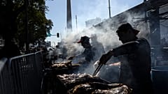 Parrilleros asan carne para la venta en un puesto durante un campeonato de asado en Buenos Aires, Argentina, el 14 de agosto de 2022.