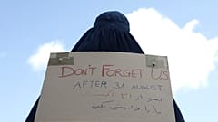 سيدة أفغانية ترتدي البرقع وتحمل لافتة مكتوب عليها لا تنسونا أمام السفارة الفرنسية في كابول، أفغانستان.   