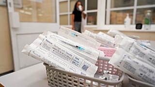 قوارير لقاح فايزر ضد كوفيد جاهزة للاستخدام في مدرسة سوامينارايان في لندن، بريطانيا.