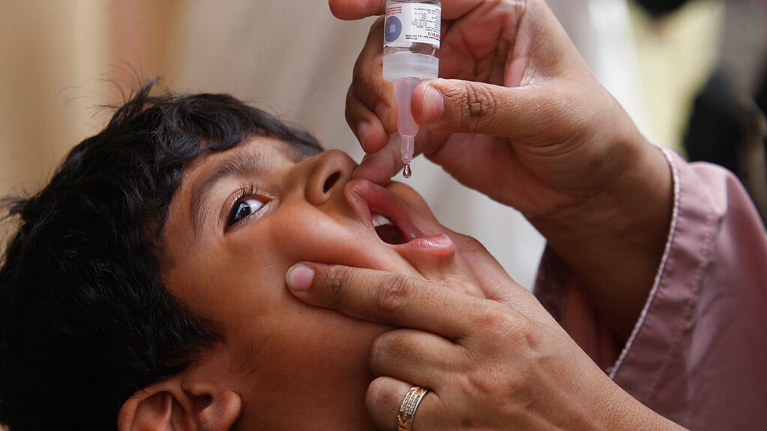 ممرض يعطي لقاح شلل الأطفال لطفل في كراتشي، باكستان، في 23 مايو/أيار 2022.