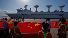 Les employés du port d'Hambantota tendent un gigantesque drapeau chinois sur les quais pour accueillir le navire chinois Yuan Wang 5 le 16 août 2022.