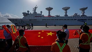 Les employés du port d'Hambantota tendent un gigantesque drapeau chinois sur les quais pour accueillir le navire chinois Yuan Wang 5 le 16 août 2022.