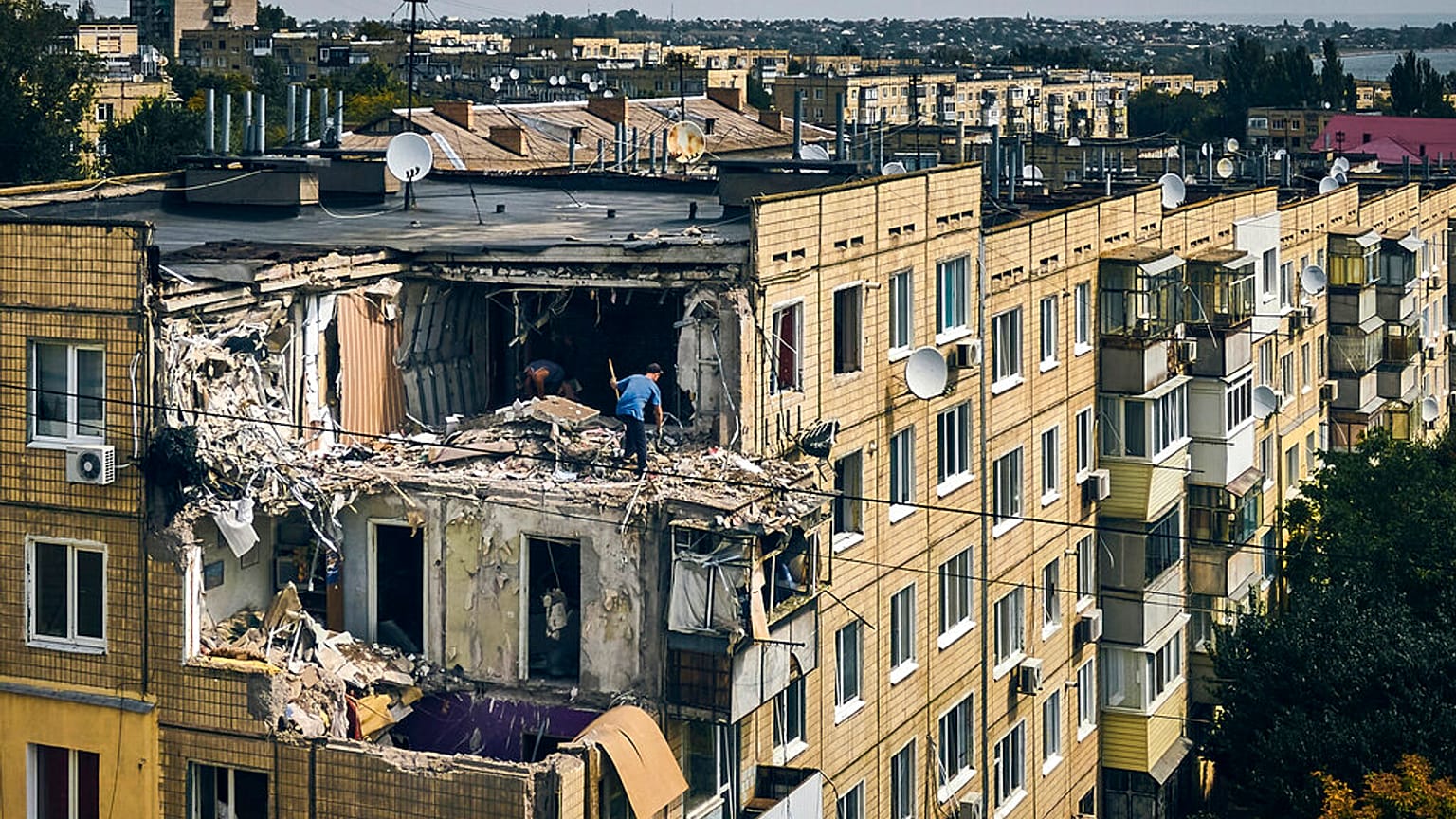 A man cleans an apartment destroyed after Russian shelling in Nikopol, Ukraine, Monday, Aug. 15, 2022.