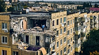 A man cleans an apartment destroyed after Russian shelling in Nikopol, Ukraine, Monday, Aug. 15, 2022.
