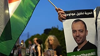 متظاهرون يحملون بالعلم الفلسطيني وصور الأسير الفلسطيني خليل عواودة المضرب عن الطعام منذ 165 يوماً، بئر يعقوب، قرب مدينة نابلس بالضفة الغربية، 13 أغسطس ، 2022.