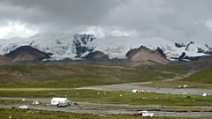Des pèlerins et des bergers campent au pied de la chaîne de montagnes tibétaines sacrées Amnye Machen, à la limite orientale du plateau tibétain (août 2018).$