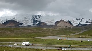 Des pèlerins et des bergers campent au pied de la chaîne de montagnes tibétaines sacrées Amnye Machen, à la limite orientale du plateau tibétain (août 2018).$