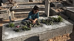 Egy palesztin lány rózsát helyez a Nijim család egyik gyermekének sírjára a Gázai övezet északi részén fekvő Dzsabáliában lévő Al-Faluja temetőben 2022. augusztus 16-án, kedde