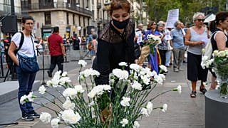 امرأة تضع زهرة في ذكرى هجوم برشلونة