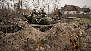 Украинский солдат на подбитом российском танке в селе Андреевка Киевской области (начало апреля 2022 г.)