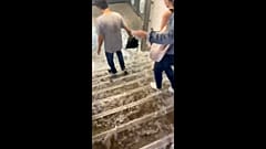 People walk as water rushes down the stairs following a heavy rainfall at Victor Hugo metro station in Paris, France August 16, 2022