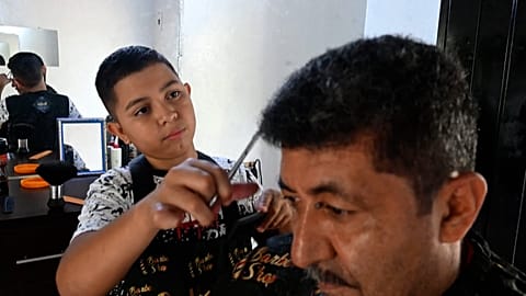 Eduardo Espinal, a 12-year-old barber.