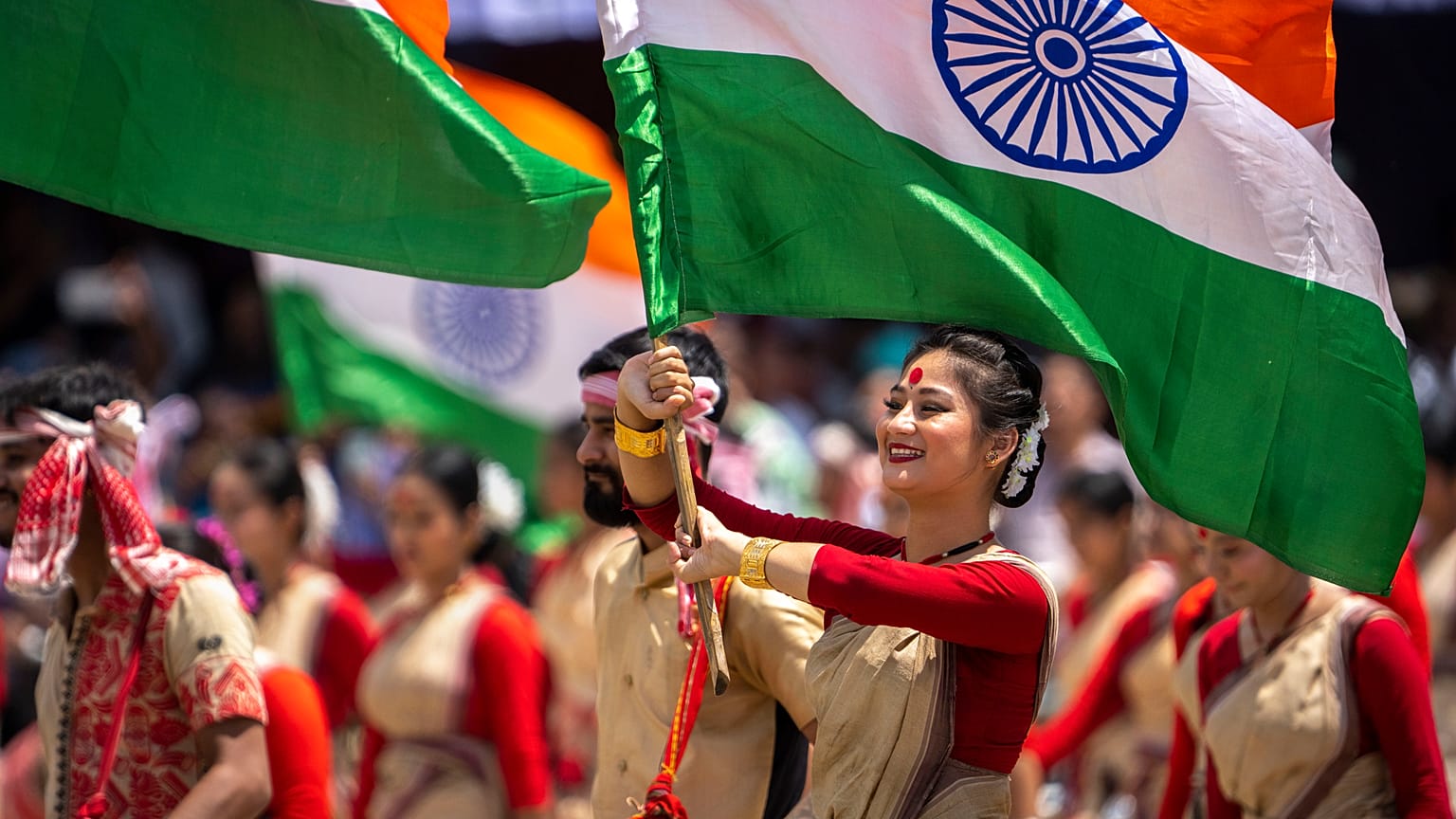 Assamese girls and boys in traditional attire carry Indian flags as they perform Bihu dance on Independence Day in Gauhati, northeastern Assam state, India, Aug. 15, 2022