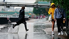 Gente corriendo bajo la lluvia en Londres tras semanas de clima sofocante, que ha provocado sequía y ha dejado la tierra reseca, el 17 de agosto de 2022. 