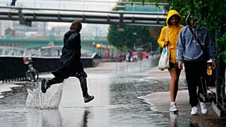Gente corriendo bajo la lluvia en Londres tras semanas de clima sofocante, que ha provocado sequía y ha dejado la tierra reseca, el 17 de agosto de 2022.