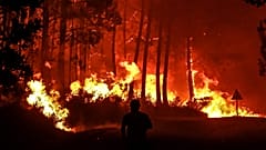 Archives : pompier luttant contre les flammes dans le secteur de Landiras, dans le département du sud-ouest de la France de la Gironde, le 10 août 2022
