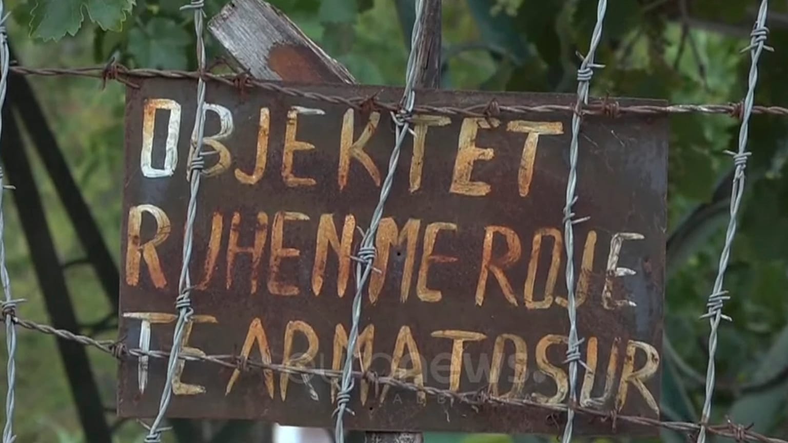 A sign at the former weapons factory in Polican, saying "The facility is being protected by armed guards".