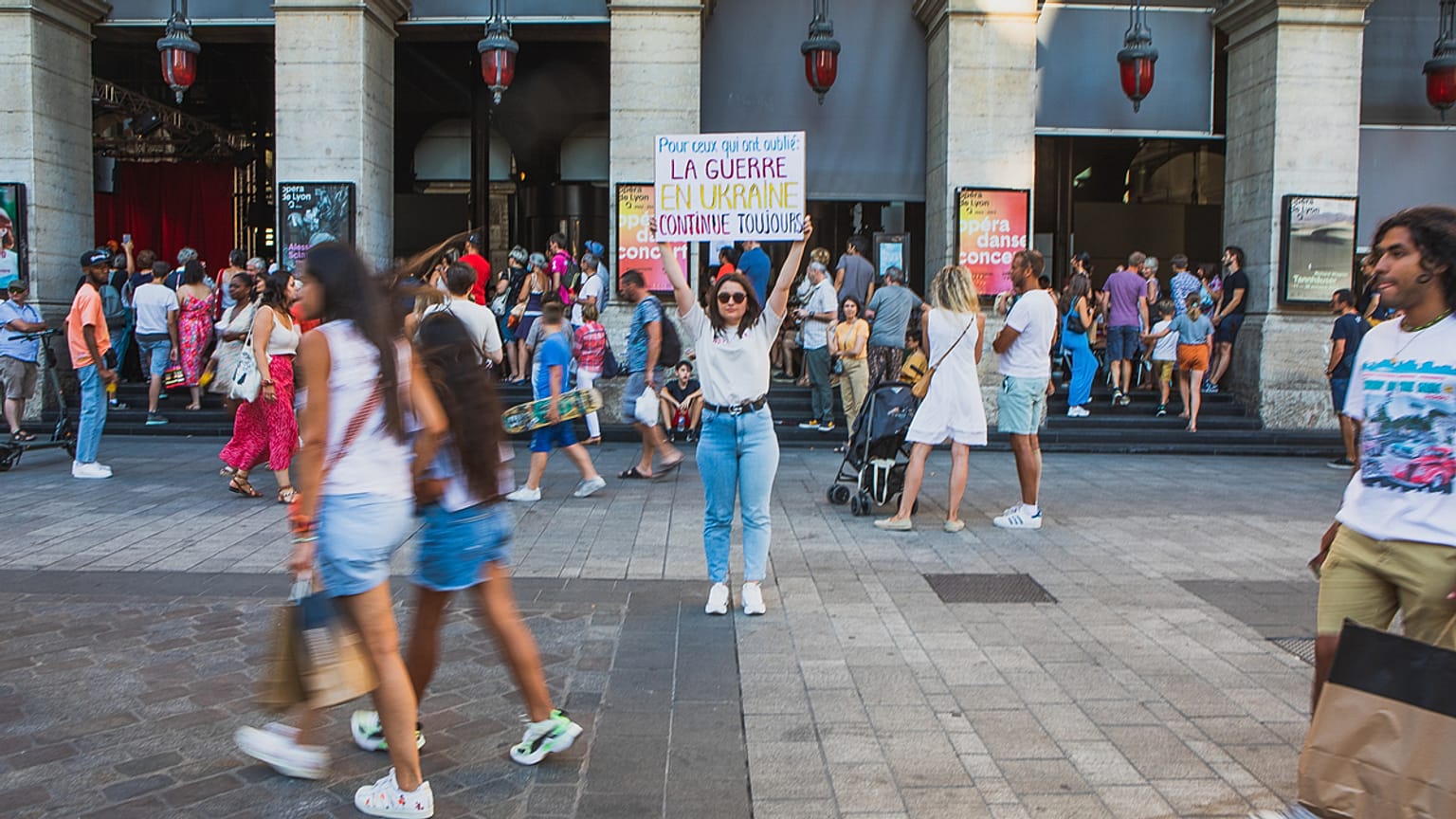 Diana Dimitrova, egy kijevi ukrán nő egy plakátot tart a kezében, amelyen ez áll: "Azok számára, akik elfelejtették: a háború Ukrajnában még mindig tart". Lyon, Franciaország