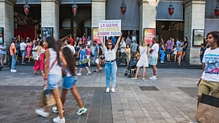 Diana Dimitrova, egy kijevi ukrán nő egy plakátot tart a kezében, amelyen ez áll: "Azok számára, akik elfelejtették: a háború Ukrajnában még mindig tart". Lyon, Franciaország