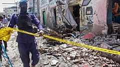 Un membro delle forze dell'ordine delimita la zona dell'attacco, che ha lasciato una scia di distruzione