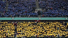 Spectators hold banners in colors of the Ukrainian flag before a friendly charity soccer match between Legia Warszawa and Dynamo Kyiv in Warsaw, 12 April 2022
