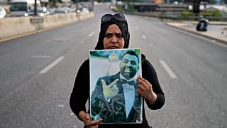 Rima Zahed tient le portrait de son frère décédé dans les explosions de 2020 pour demander aux autorités d'éteindre le feu qui détruit les silos à grains du port.