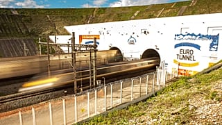 This photo taken on October 20, 2015 in Coquelles shows Eurotunnel train and shuttle entering the Eurotunnel, during the inauguration of a new Eurotunnel freight line.
