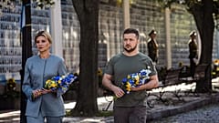 Владимир Зеленский и его супруга Алёна возлагают цветы к мемориалу с фотографиями погибших за родину