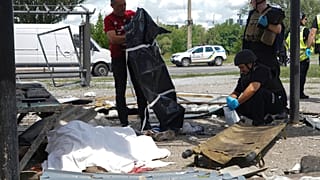 Un urgentiste ukrainien couvre les corps de personnes tuées dans une attaque à Kharkiv, Ukraine, le 10 juillet 2022.