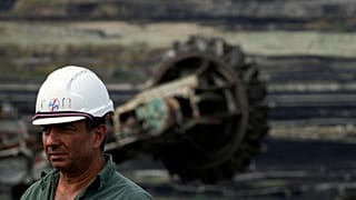 Giorgos Papadopoulos, supervisor at Public Power Company (PPC), walks near a coal excavator at Greece's largest lignite mine.