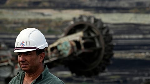 Giorgos Papadopoulos, supervisor at Public Power Company (PPC), walks near a coal excavator at Greece's largest lignite mine.