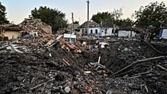 People stand next to a residential house destroyed by a Russian military strike, as Russia's attack on Ukraine continues, in Chaplyne