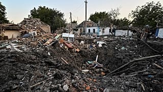 People stand next to a residential house destroyed by a Russian military strike, as Russia's attack on Ukraine continues, in Chaplyne