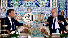 الرئيس الجزائري عبد المجيد تبون مع الرئيس الفرنسي إيمانويل ماكرون في اجتماع بصالة كبار الشخصيات بمطار الجزائر